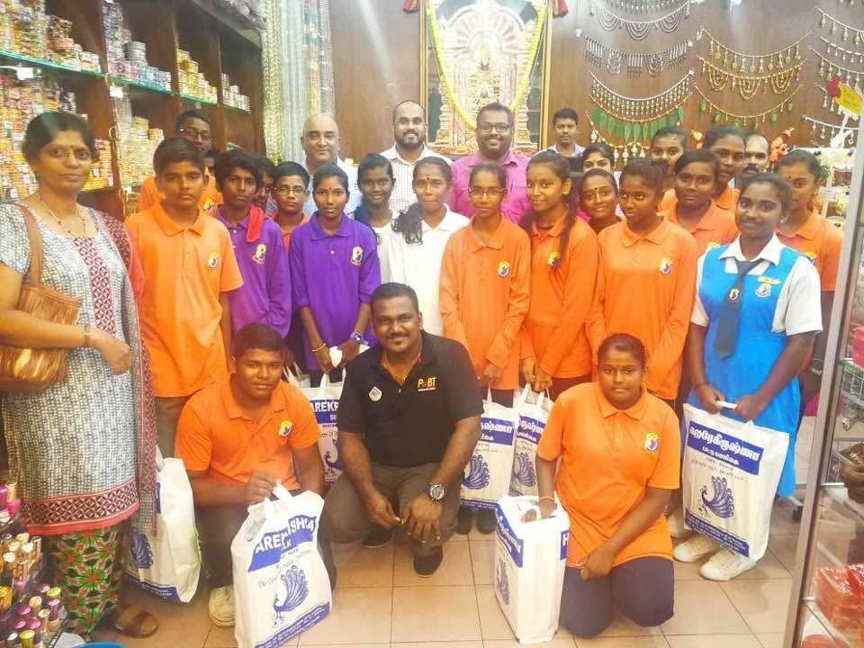 A group of young people holding filled carrier bags inside a shop